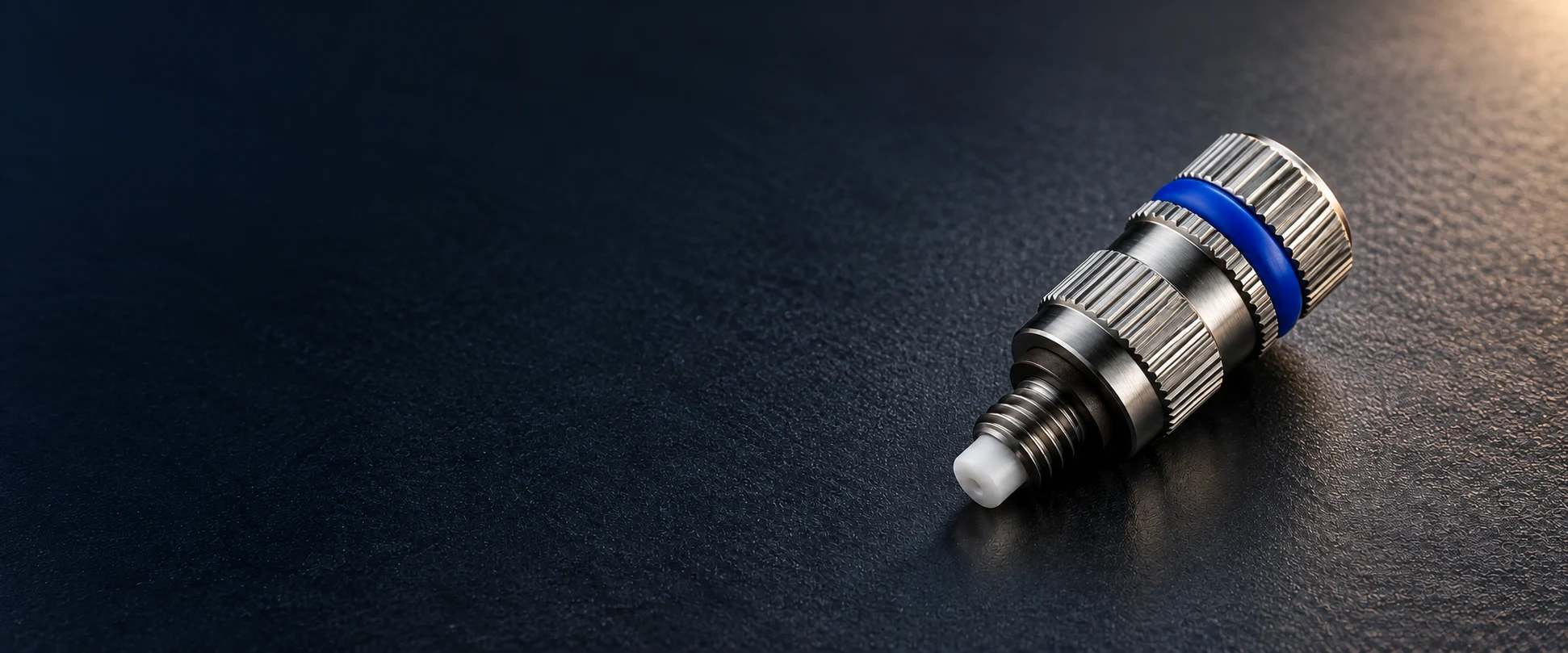 Studio visualization of the 7.94N stainless steel nozzle with blue band on a dark work surface